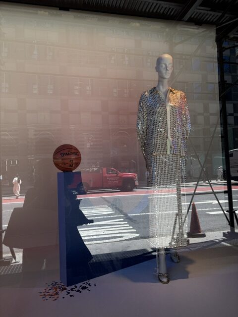 Sequined mannequin displayed beside a basketball in Bloomingdale’s New York Knicks themed window.
