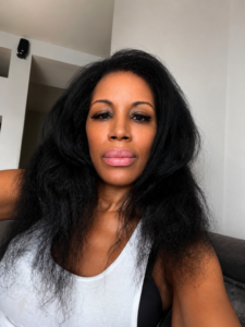 Natural hair after getting caught in the rain on a Sunday morning in New York City, wearing a white ribbed tank and embracing soft volume before running errands.