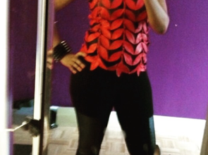Full-length mirror photo featuring a bold red and black textured top paired with black pants and coordinating red high heels.
