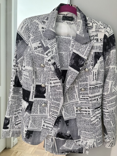 Black-and-white newspaper print blazer with a tailored silhouette, notched lapels, and silver statement buttons, showcasing an editorial-inspired design that blends classic tailoring with bold print. As well as matching pants. Fashion Inspiration was John Galliano for Dior.